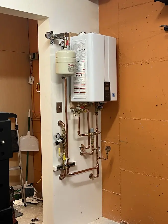 Plumbing technician inspecting water heater connections in Coos Bay